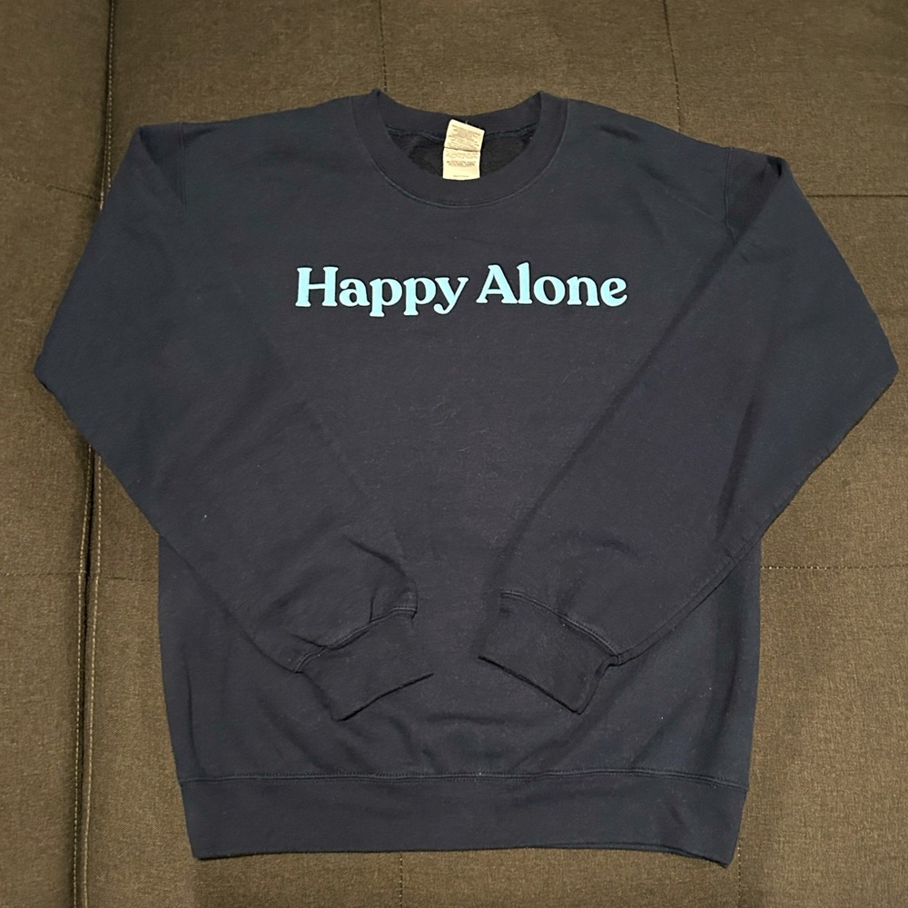 Navy blue “Happy Alone” sweatshirt.